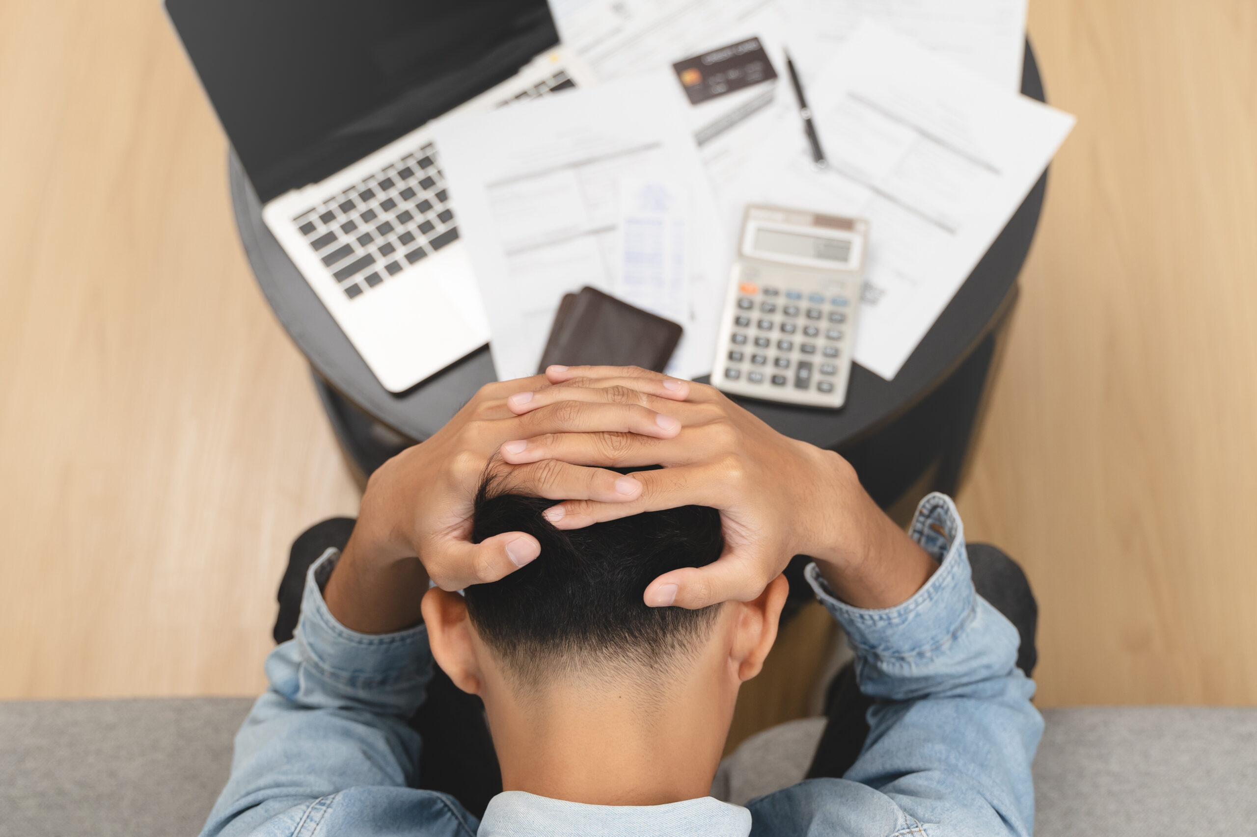 Household financial economic concept, Stressed Young Asian adults are looking at credit card bills issued documents, and apartment loan mortgages and worrying about having no money to pay.